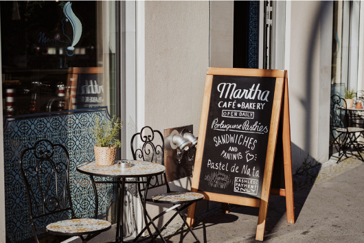 Cafetisch mit zwei Stühlen un einem Aufsteller im Cafe Martha Berlin